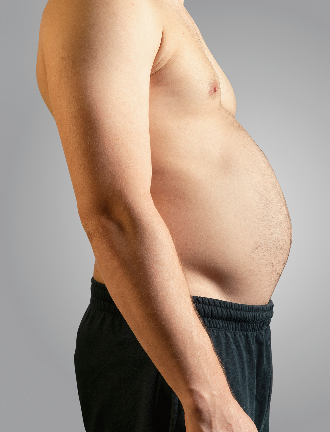 Person wearing dark pants, bare-chested side profile